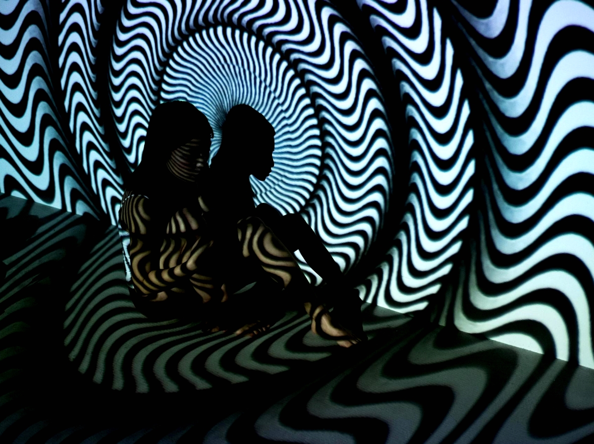 A woman with a hypnotic, black and white field projected on her