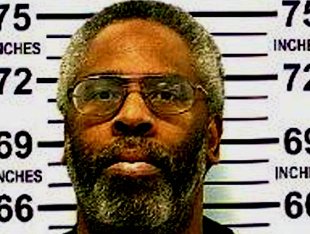 A mugshot of serial killer Kendall Francois, a bespectacled Black man with a graying beard