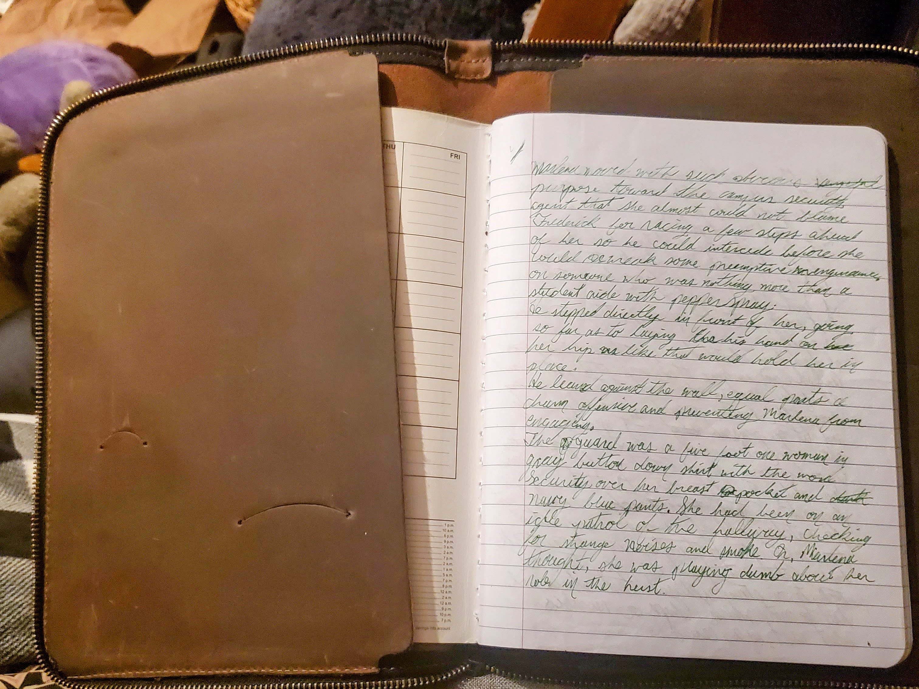 A composition notebook with green writing in it with a leather cover