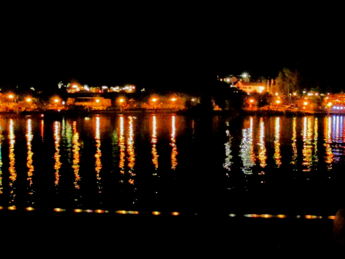 multi-colored lights distorted in reflection on a river