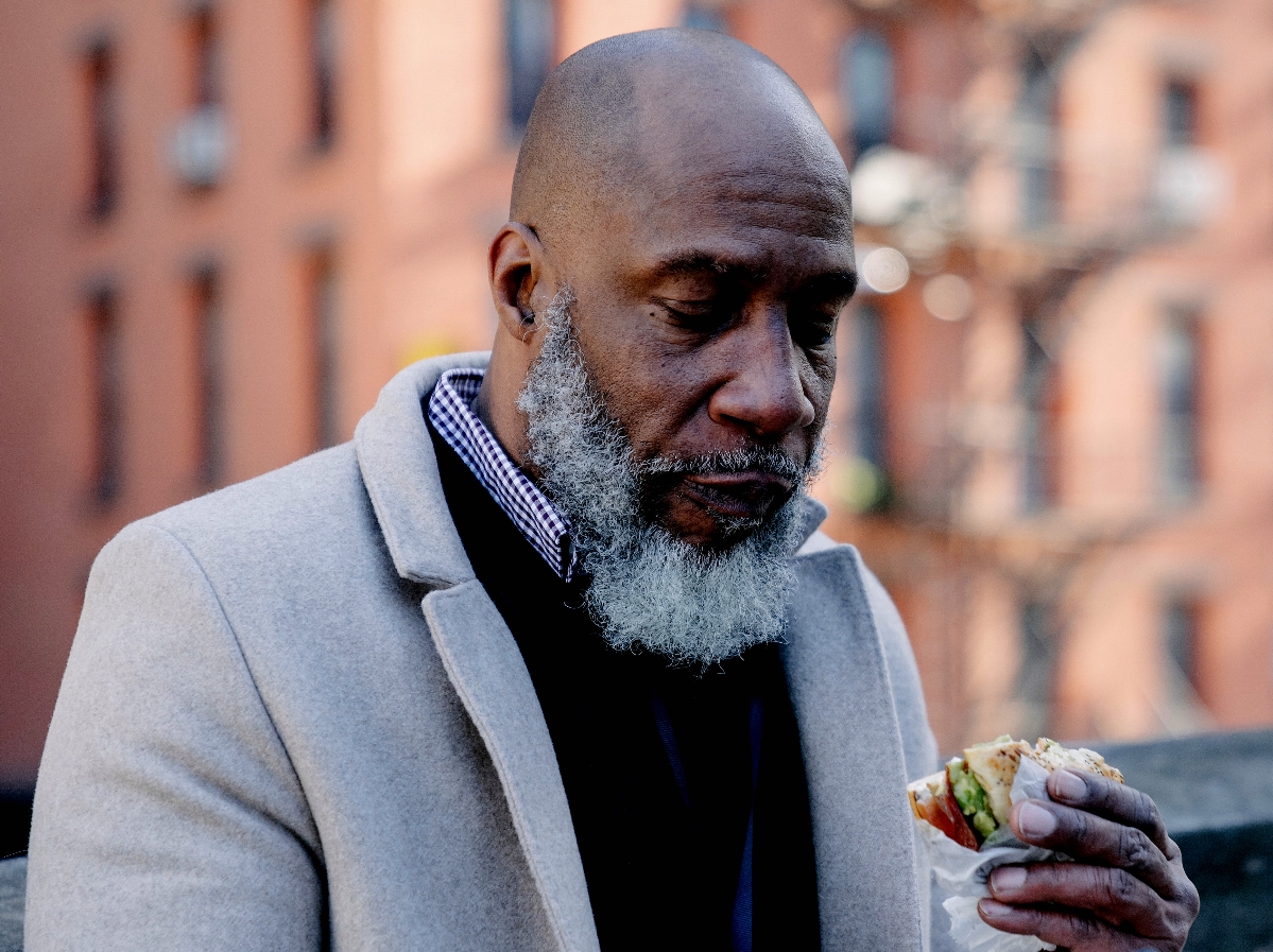 An older Black man with a beard eating