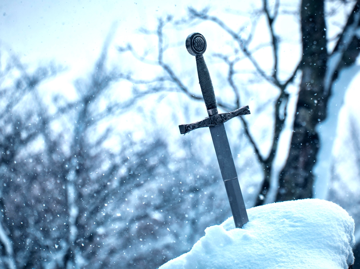 A sword embedded upright in a snow bank