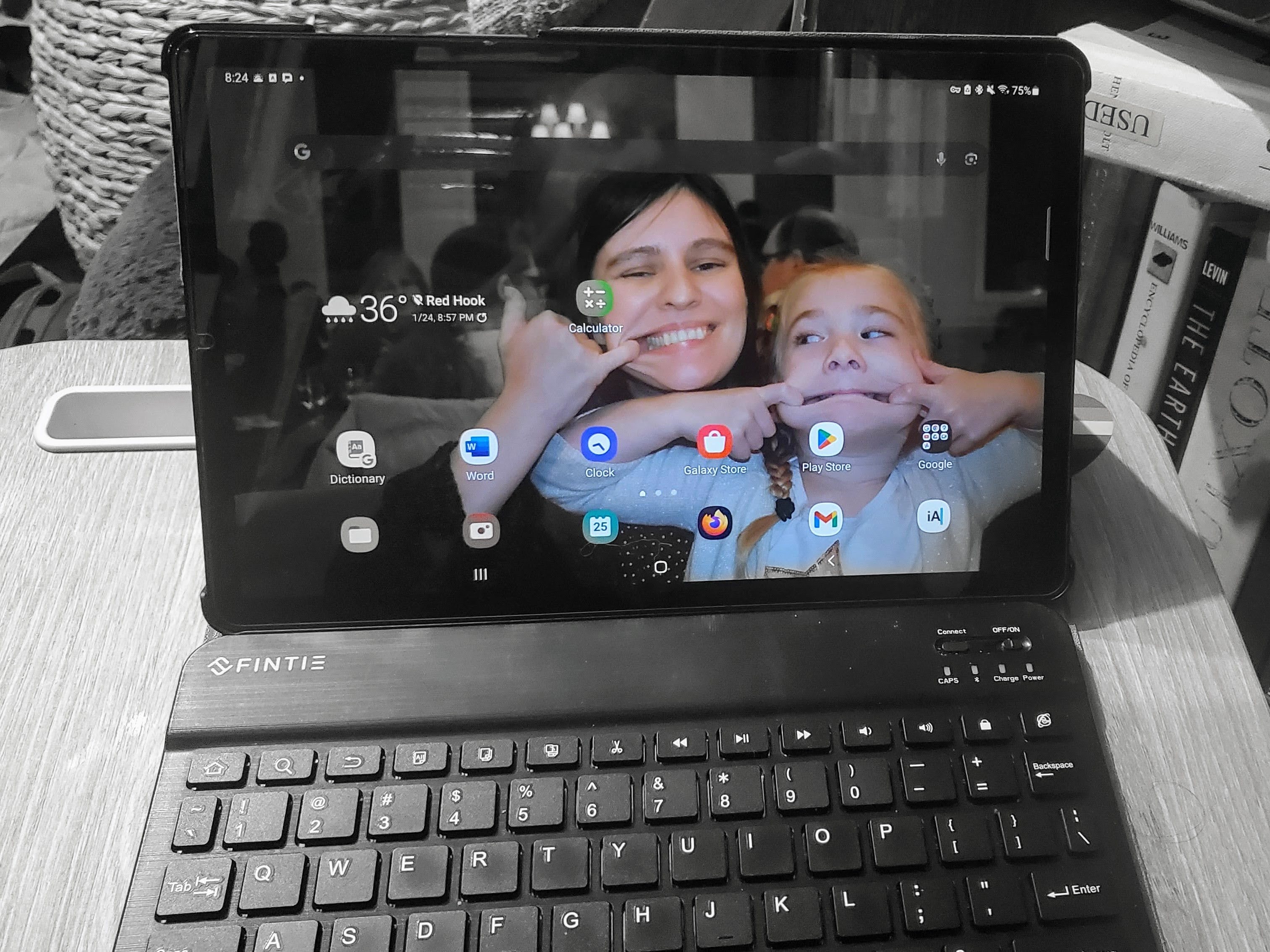 A Galaxy tablet with a picture of an adult and child making silly faces